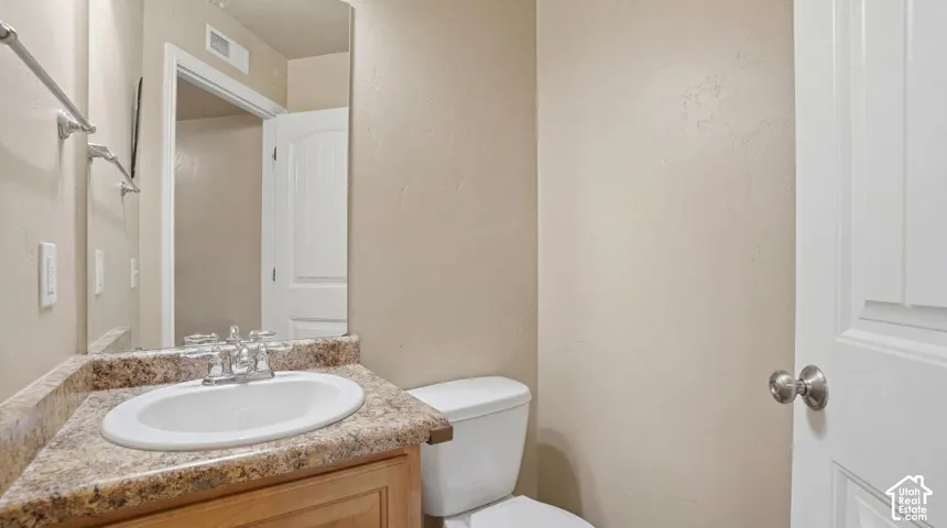 Bathroom vanity featuring an oval undermount sink, dual-handle faucet in a chrome finish, and a stone-look countertop