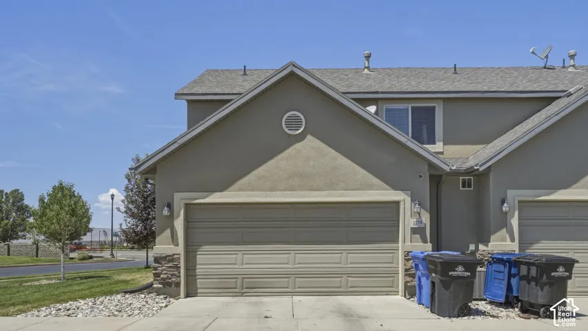 Stucco exterior with a pitched roofline and an attached garage