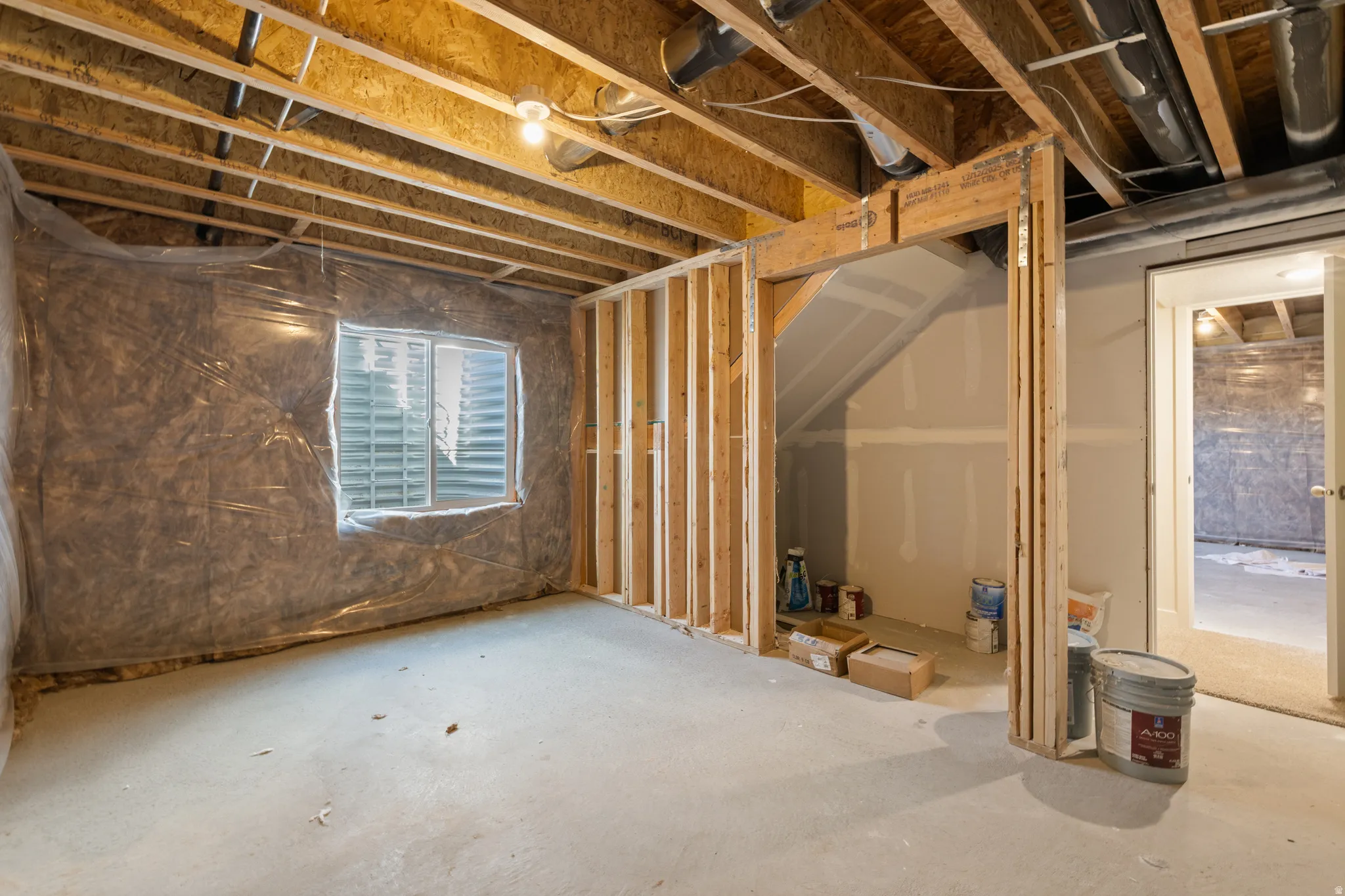 Unfinished basement space featuring exposed wood joists and concrete flooring