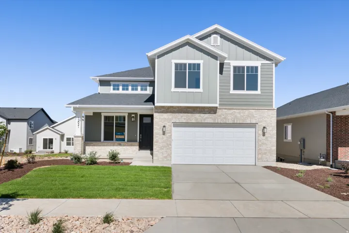 Contemporary two-story residence featuring light gray siding and stone veneer accents