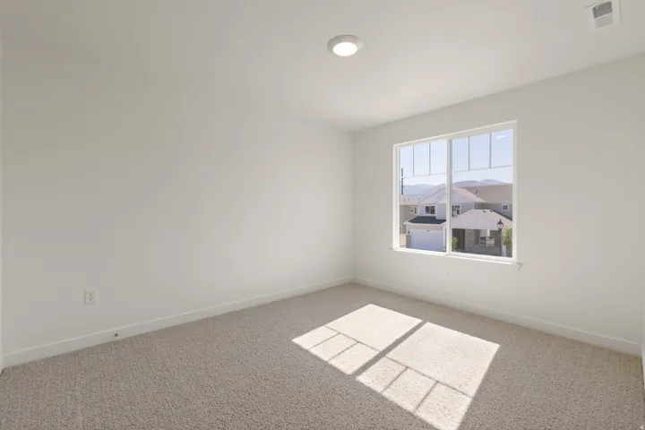 Carpeted room with white walls, a single window, and a flush-mount ceiling light