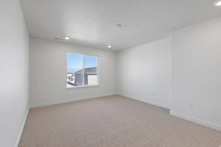 Bright room featuring light-toned carpeting and white walls