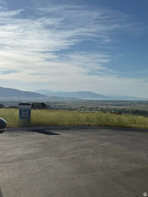 Paved lot offering expansive natural scenery featuring distant mountains and a body of water