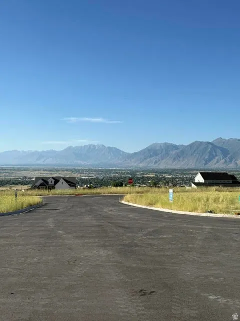 Paved road leading to building sites with expansive mountain and valley scenery