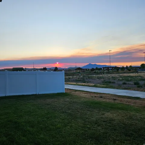 Expansive green lawn with a white vinyl fence