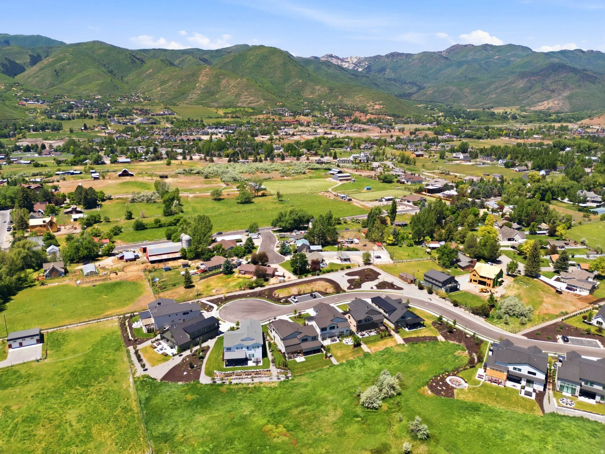 Expansive mountain-backed landscape featuring a residential cul-de-sac with modern architecture