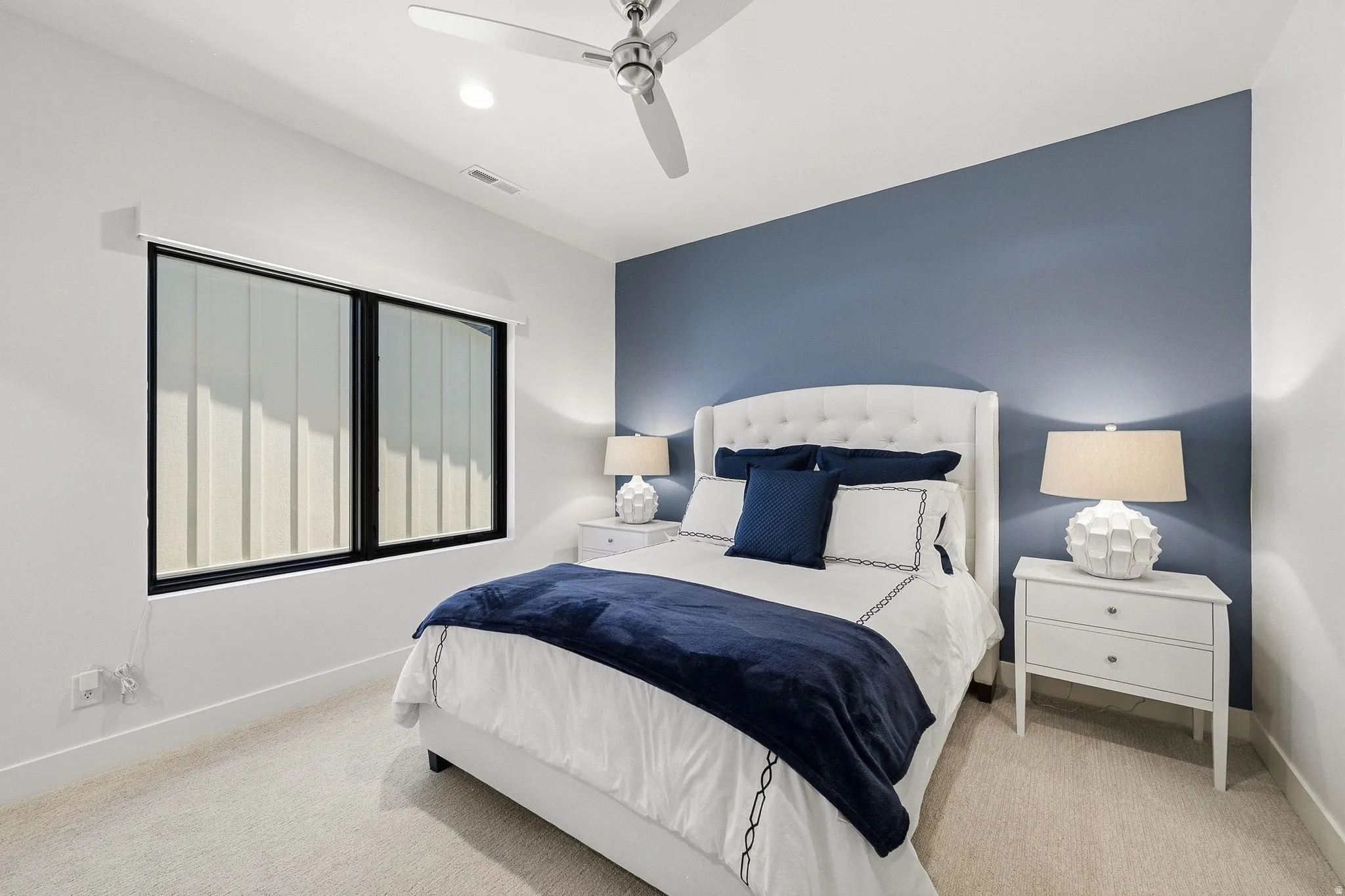 Bedroom featuring a contemporary ceiling fan, recessed lighting, a large window with vertical blinds, and soft carpeting