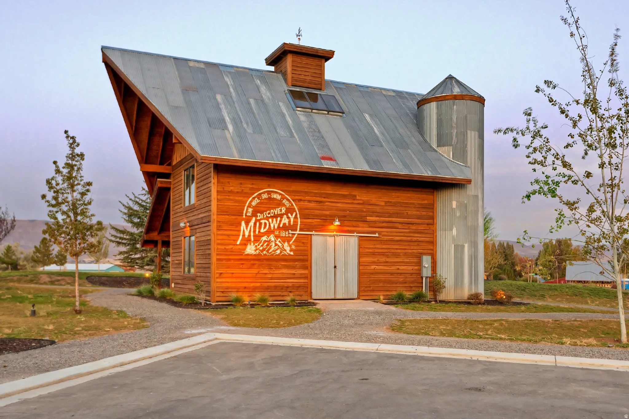 Rustic modern barn structure featuring horizontal wood siding and a corrugated metal roof