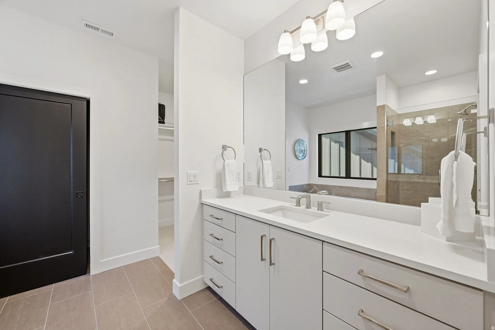 Double vanity with an integrated rectangular sink, widespread faucet, and a large mirror