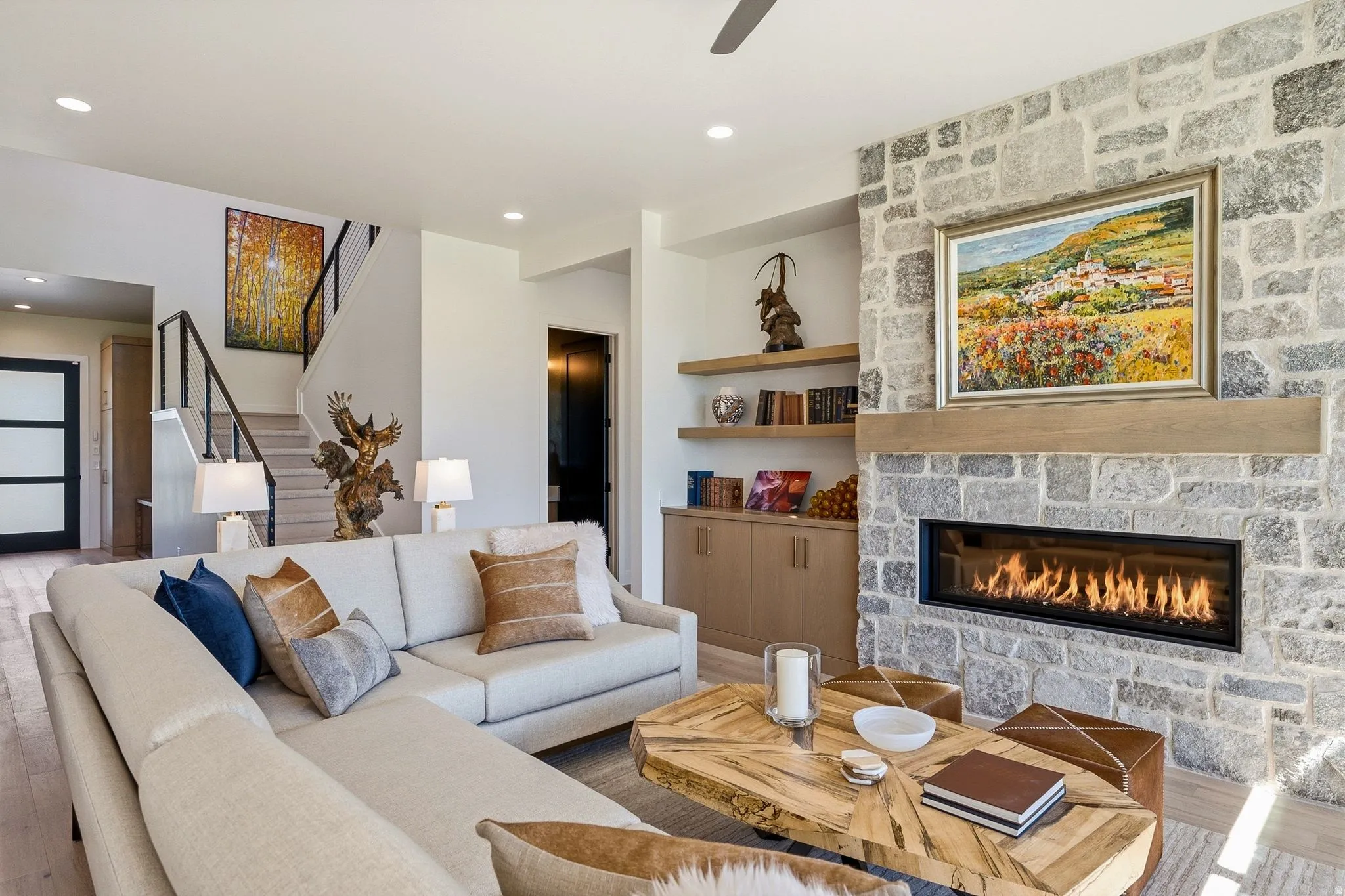 Living area featuring a stone-clad fireplace with a linear firebox and a substantial wood mantel