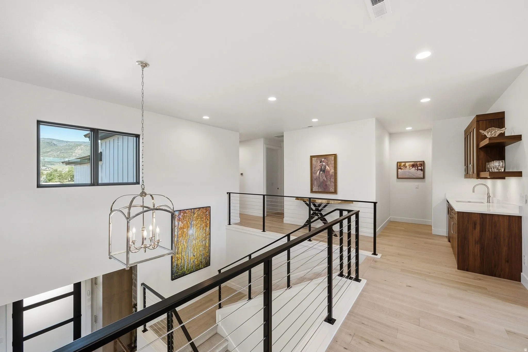 Upper-level landing featuring a wet bar with a white countertop and wood-finish cabinetry