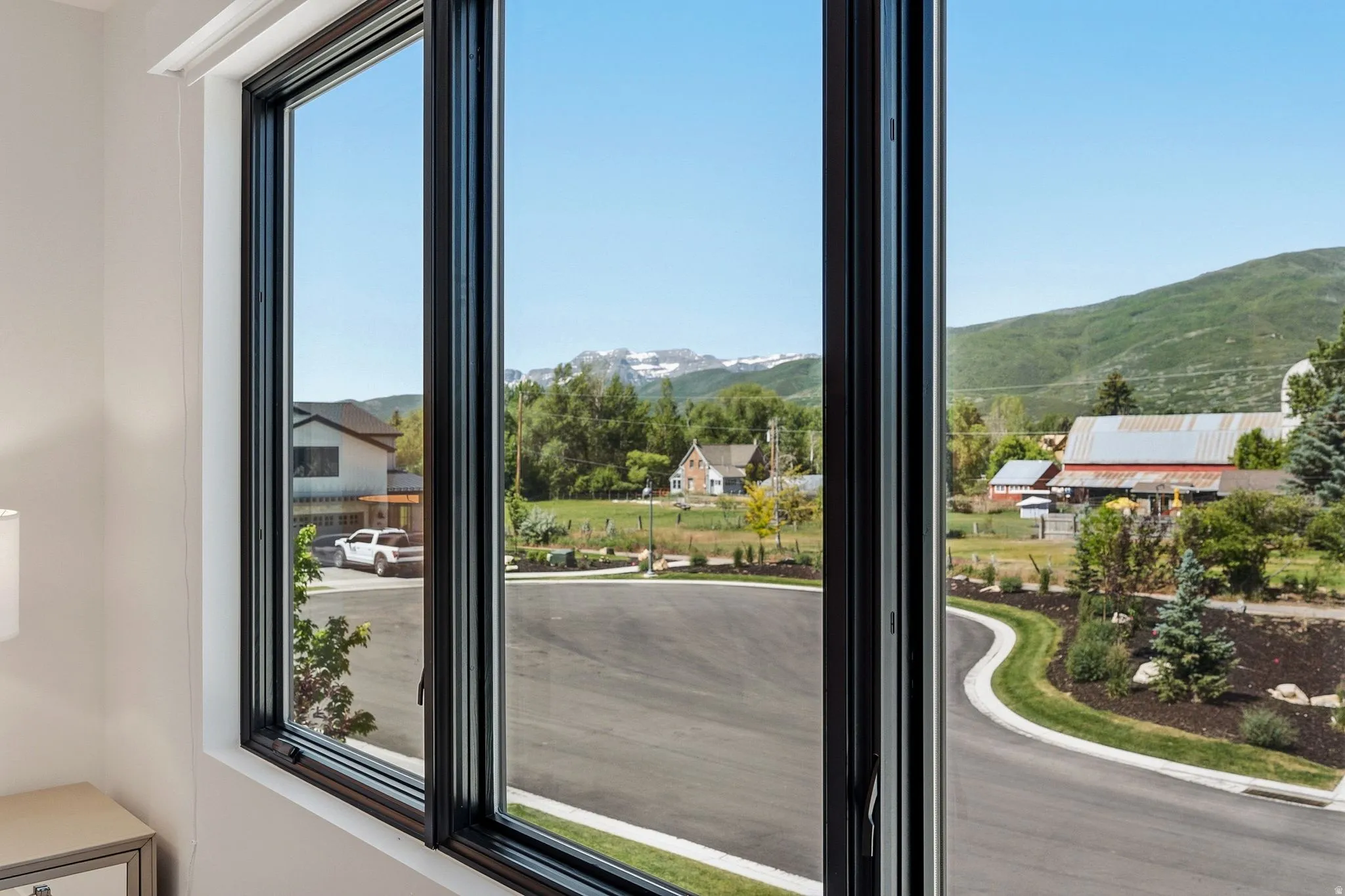 Expansive black-framed windows with mountain and pastoral scenery