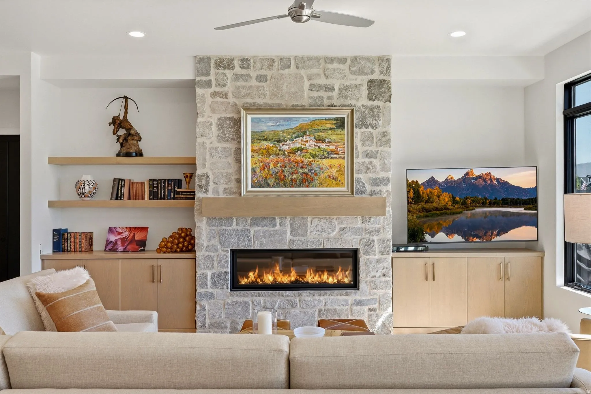 Stone-clad fireplace with a linear gas insert and a natural wood mantel