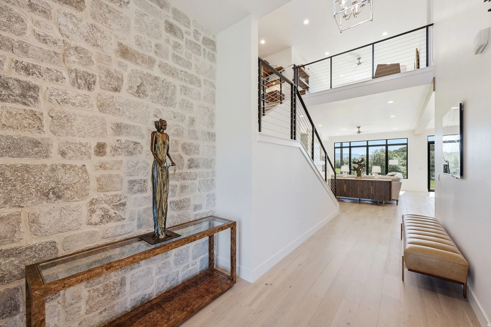 Entryway featuring a stone accent wall, light wood-finish flooring, and an open-concept design