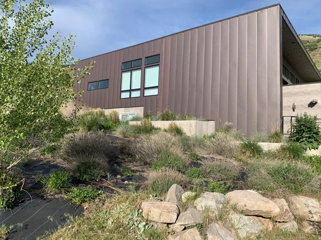 Modern exterior featuring vertical panel siding and a concrete retaining wall