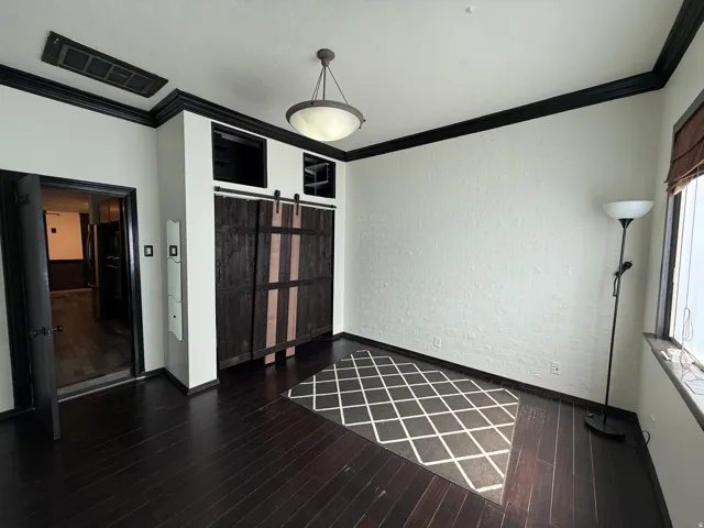 Dark wood-finish flooring with coordinating crown molding