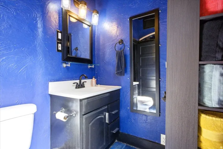 Bathroom featuring a vanity with a white countertop, dark cabinetry, and a black faucet