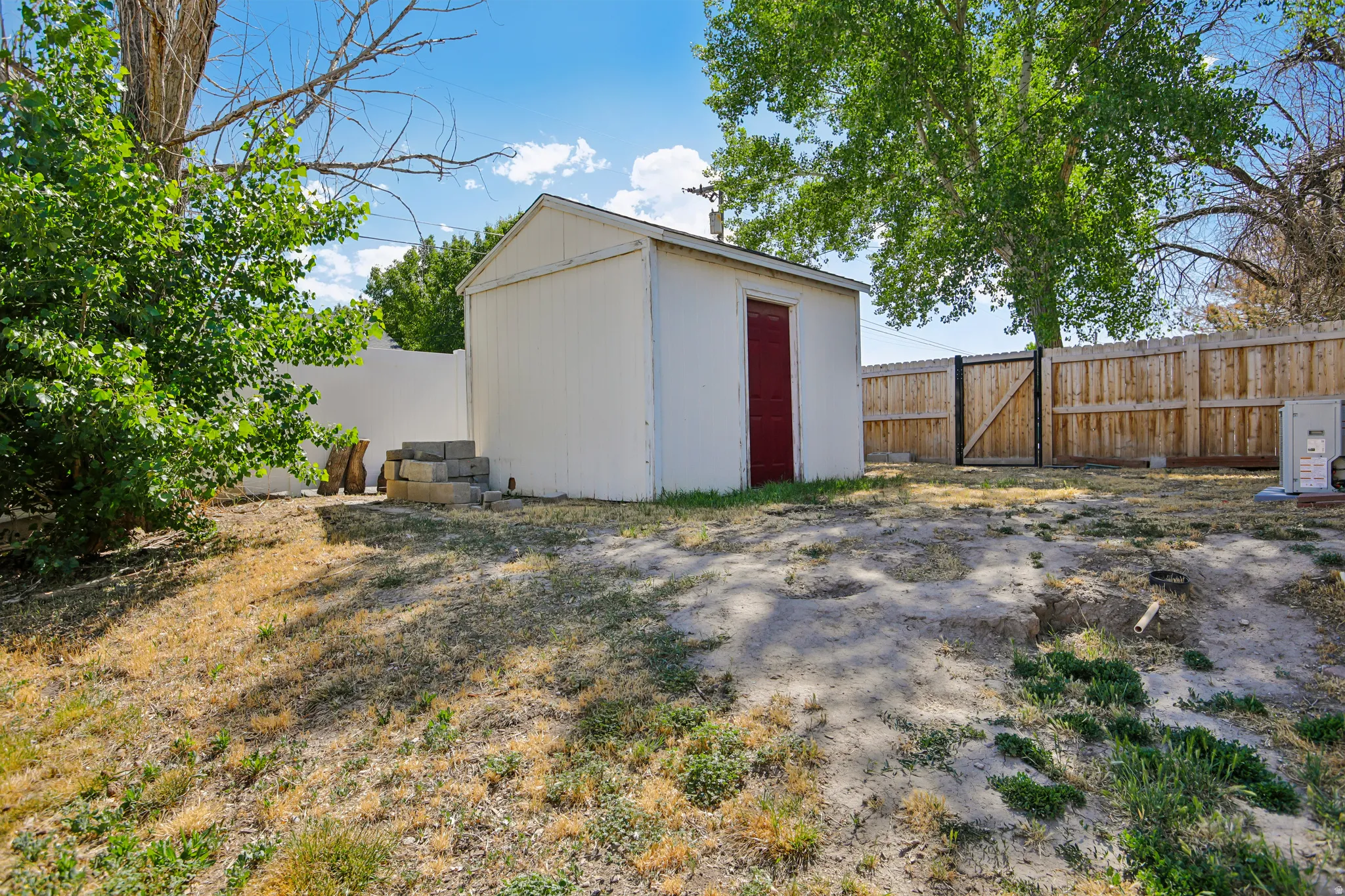 White storage shed with a red door