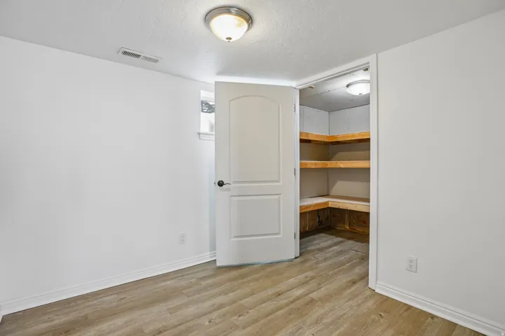 Room featuring wood-finish flooring, white baseboards, and a semi-flush mount ceiling light