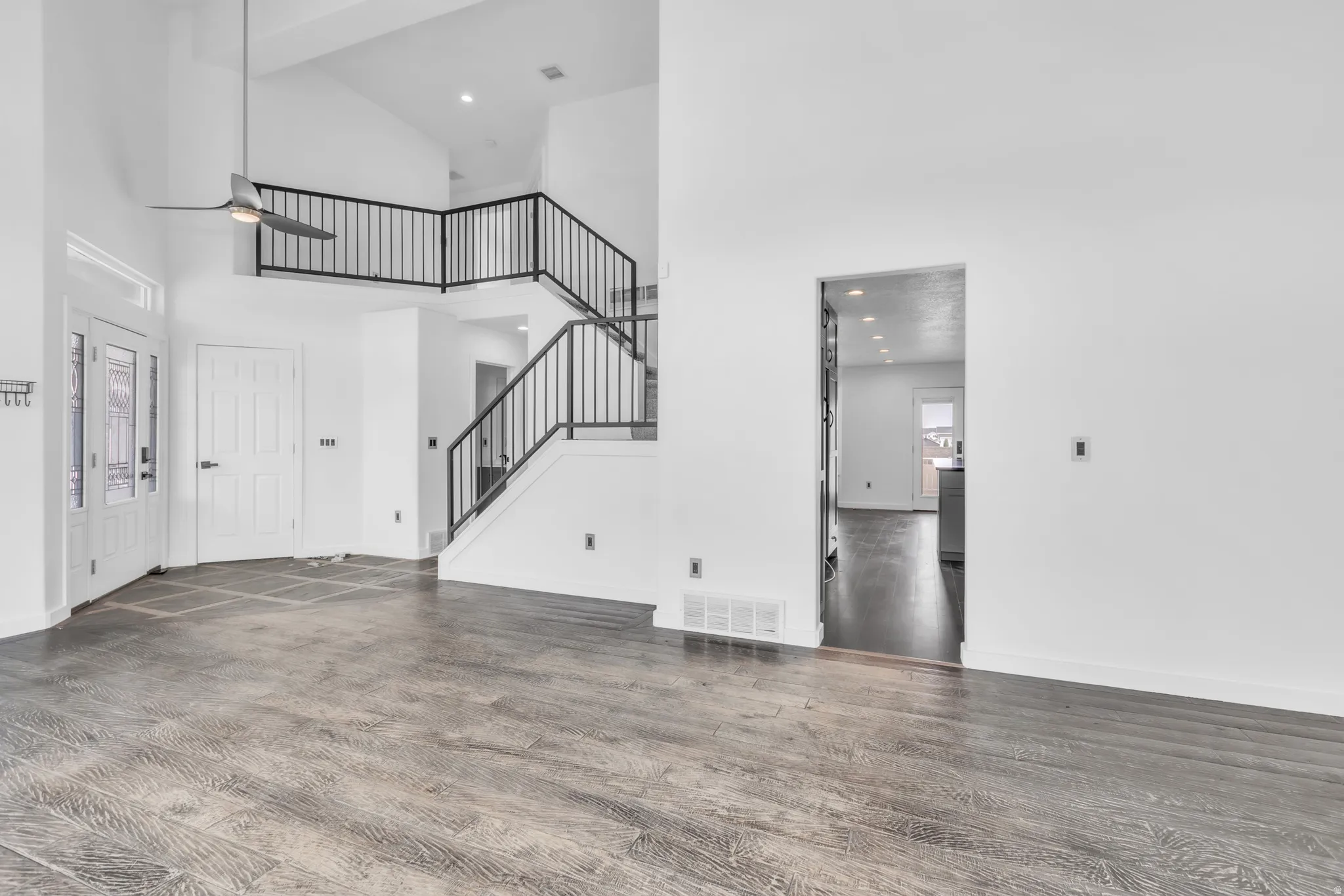 Vaulted entry with an open staircase featuring dark metal railings