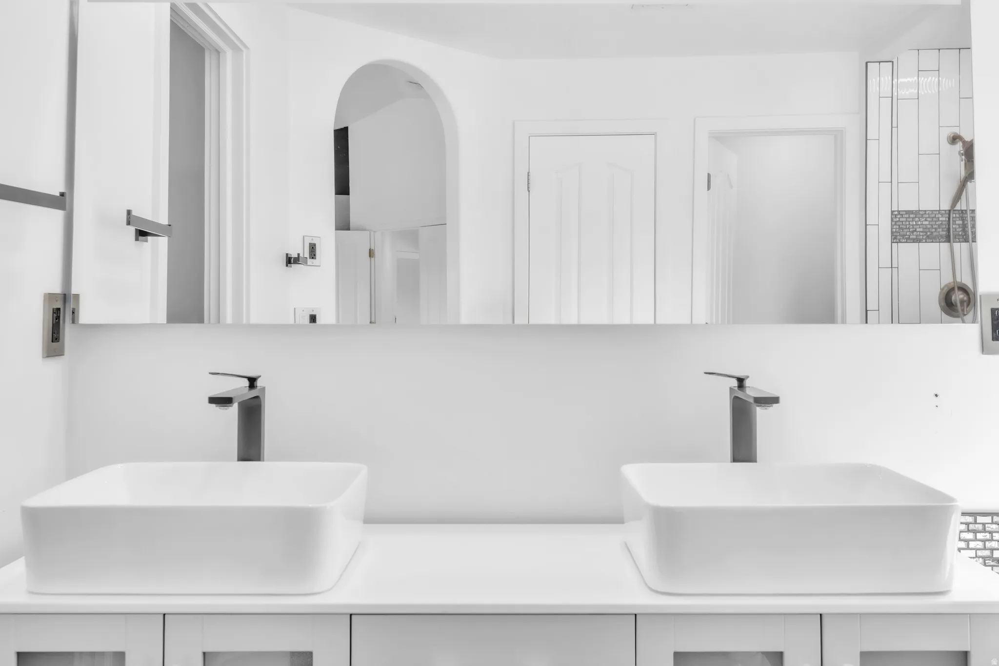 Dual vessel sinks with matte black single-handle faucets, set on a white countertop