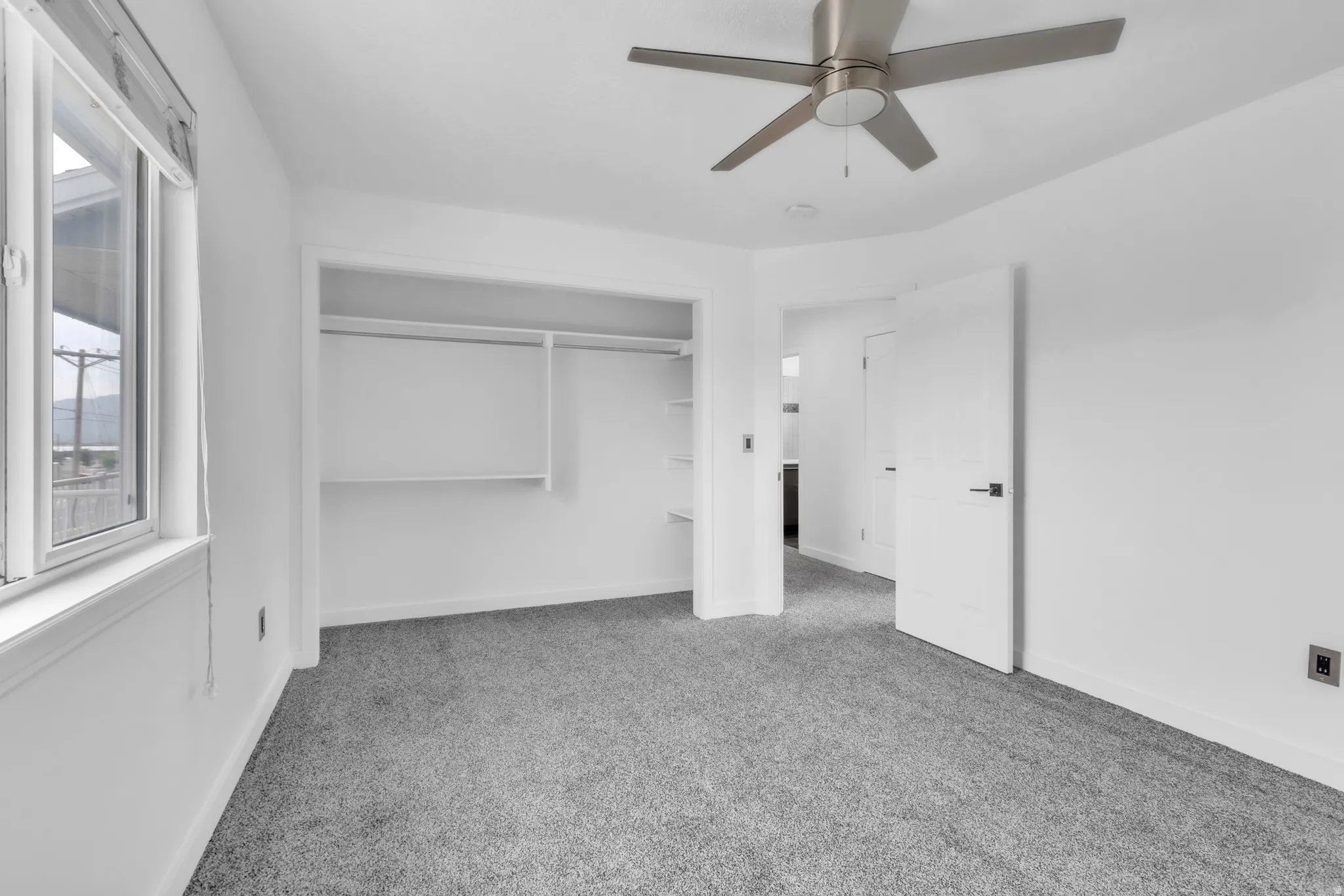 Bedroom featuring gray carpet, a ceiling fan with brushed nickel finish, and a window with white trim