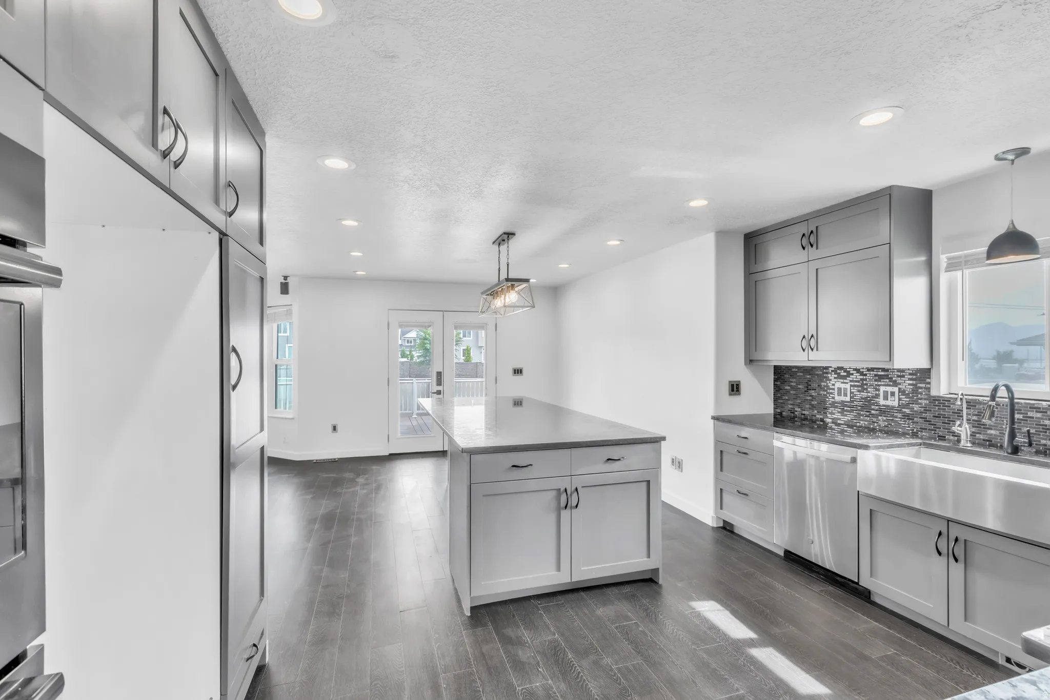 Modern kitchen featuring dark wood-finish flooring, recessed lighting, and light gray cabinetry