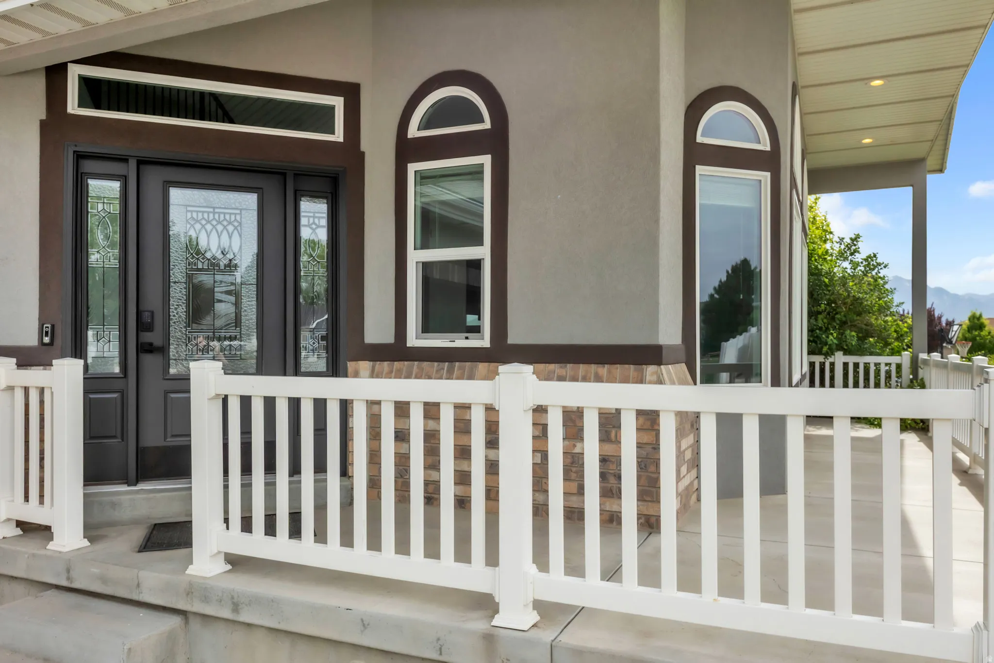 Entryway featuring a dark paneled door with decorative glass, flanked by sidelights and a transom window