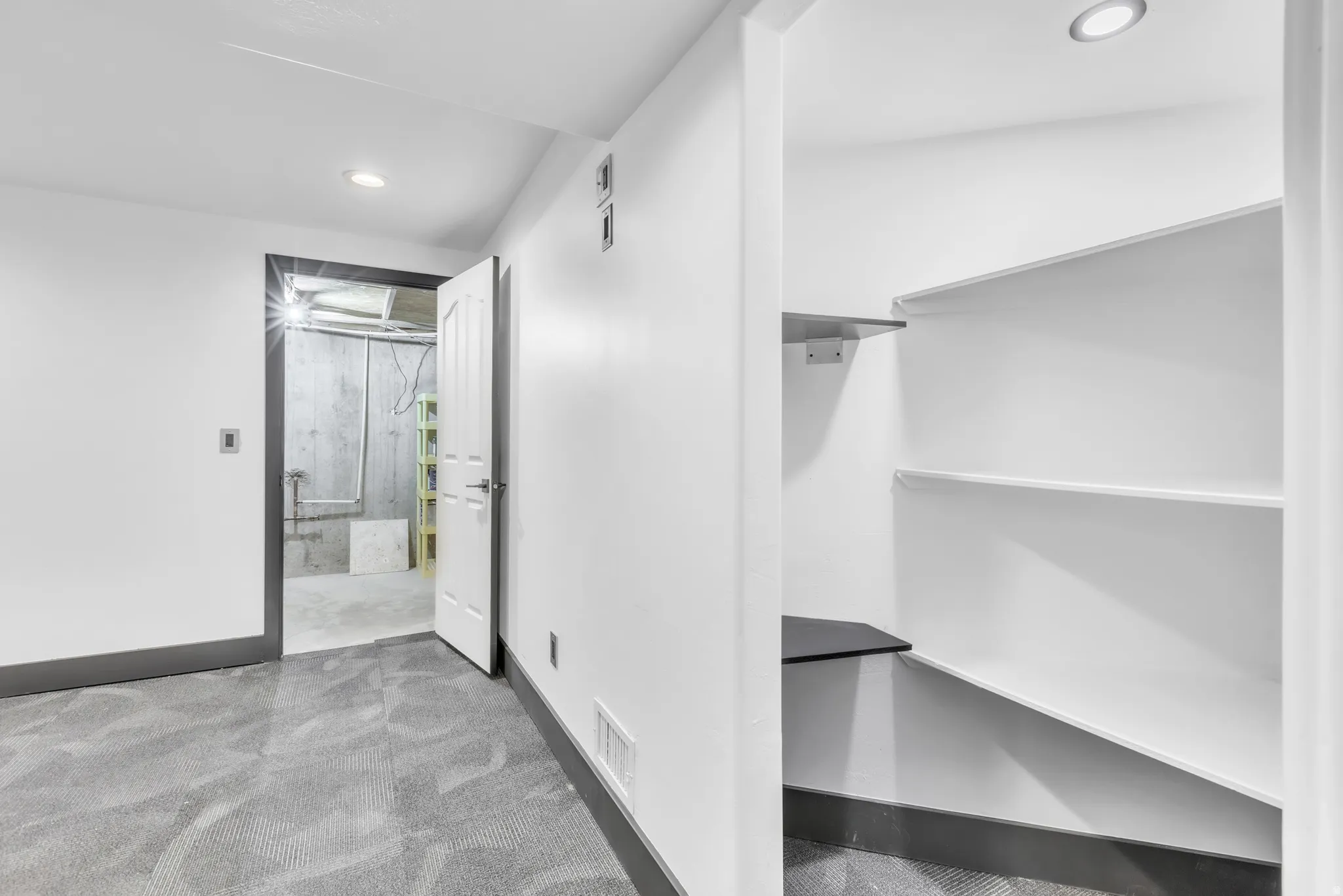 Finished interior space with grey patterned carpet and white walls