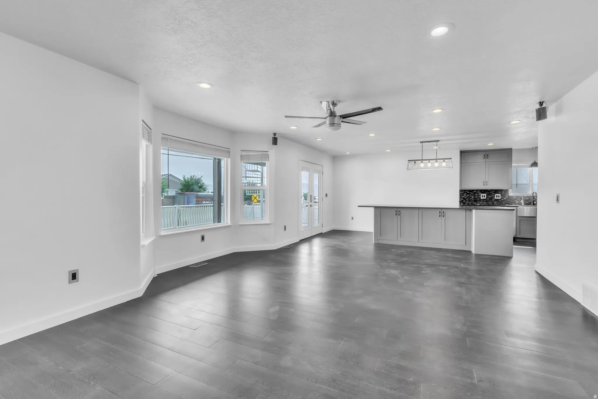 Open concept living area featuring dark wood-finish flooring, recessed lighting, and a modern ceiling fan