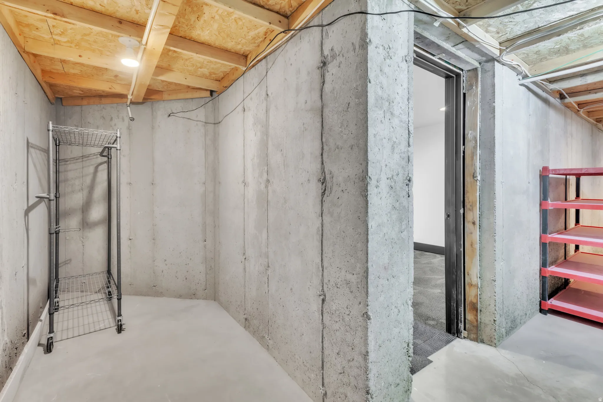 Unfinished basement area featuring exposed concrete walls and flooring