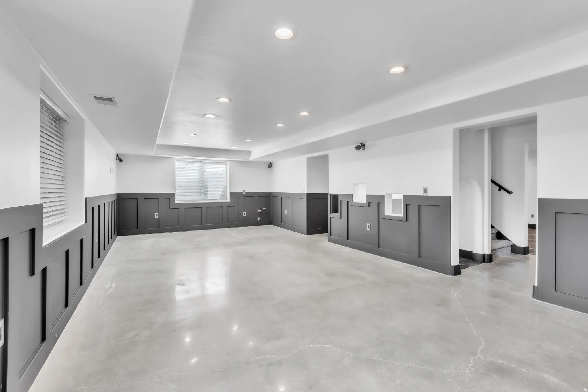 Expansive room featuring polished concrete flooring and wainscoting