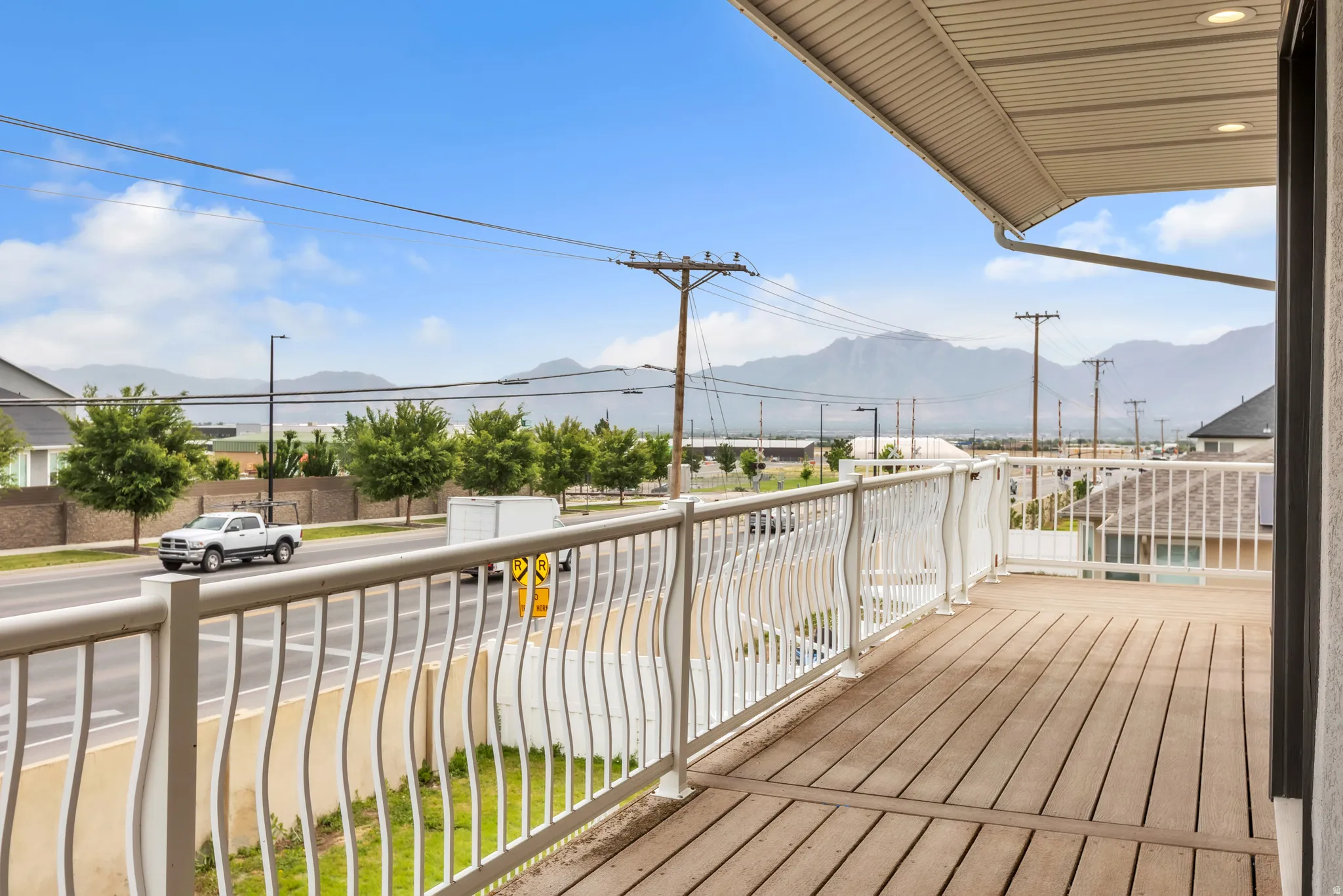 Exterior deck featuring wood-finish flooring and a white metal railing