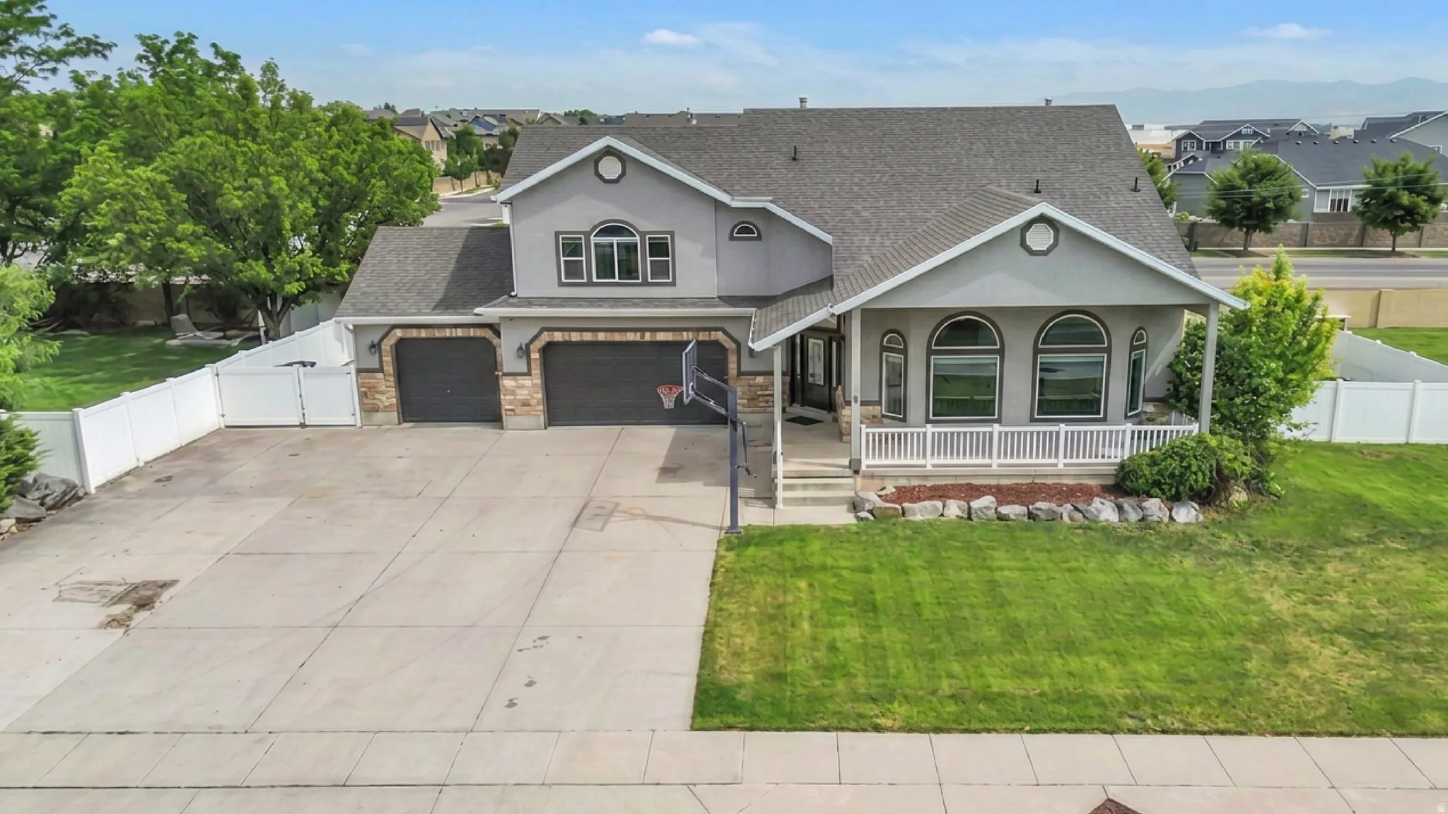Two-story residence featuring a gray exterior and a dark gray shingle roof
