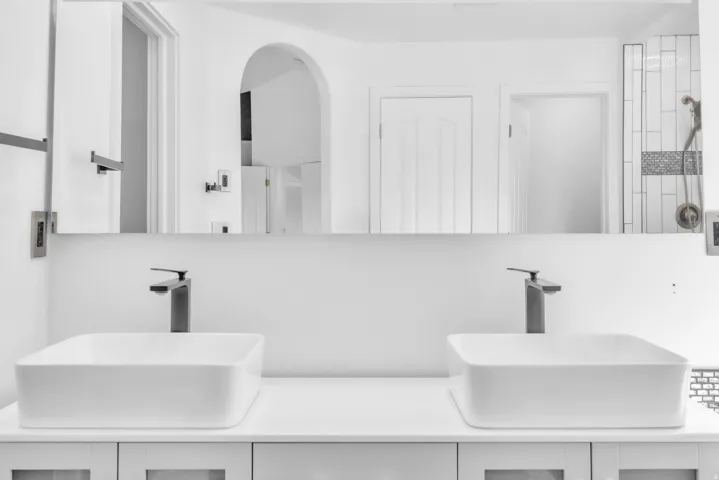 Dual vessel sinks with matte black single-handle faucets, set on a white countertop