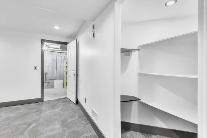 Finished interior space with grey patterned carpet and white walls