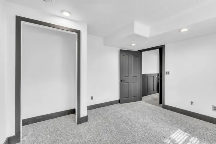 Carpeted room with recessed lighting and white walls