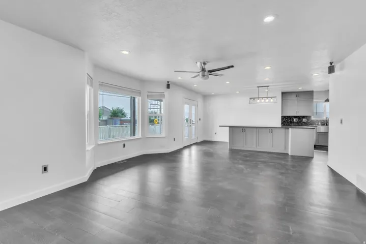Open concept living area featuring dark wood-finish flooring, recessed lighting, and a modern ceiling fan
