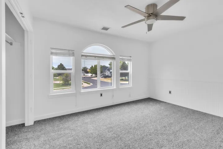 Triple window bank featuring an arched transom and white window treatments