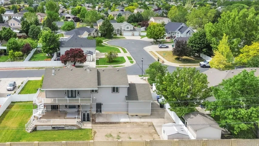 Two-story residence featuring a second-level deck with white railings and spiral staircase access