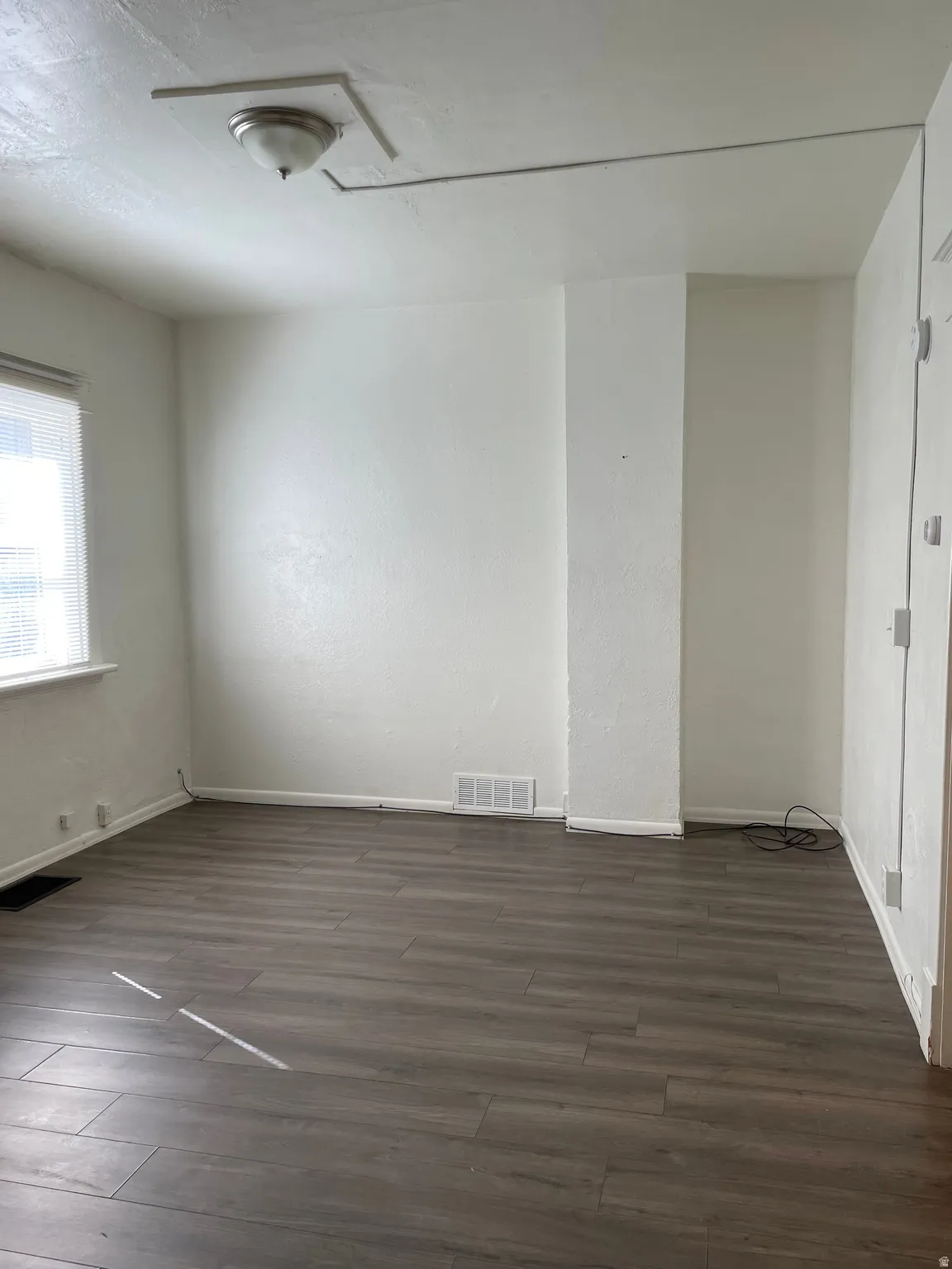 Neutral-toned wood-finish flooring complements white walls