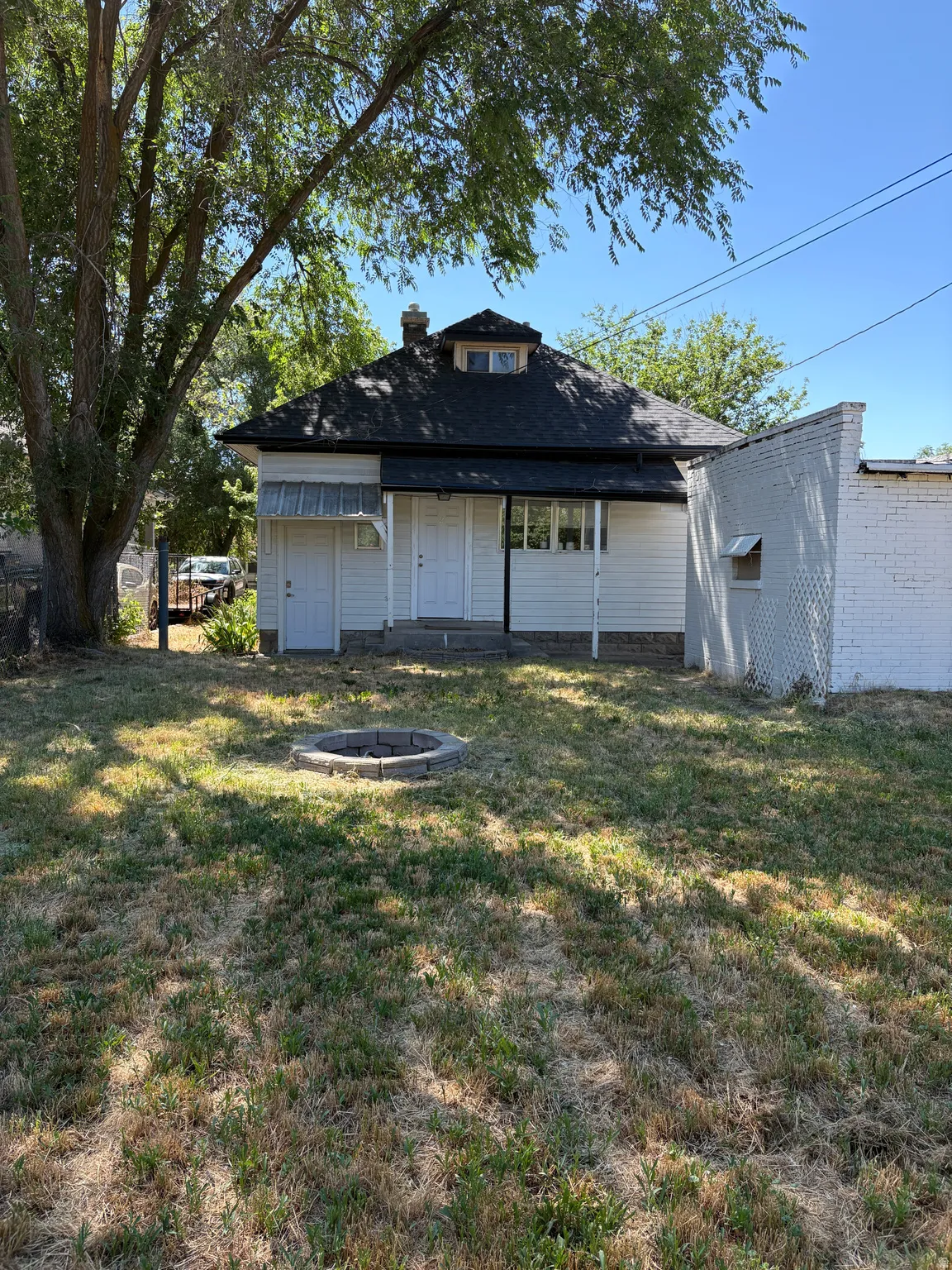 Rear exterior featuring white siding and a dormer window