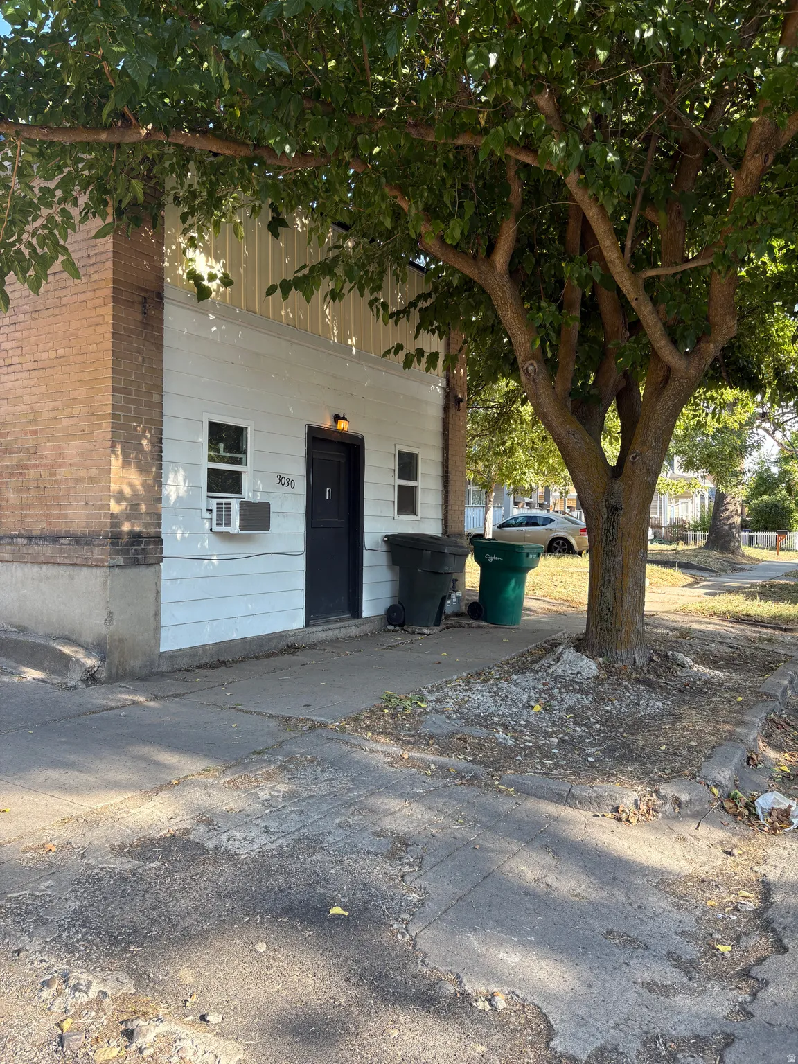 White siding exterior with a brick-clad corner