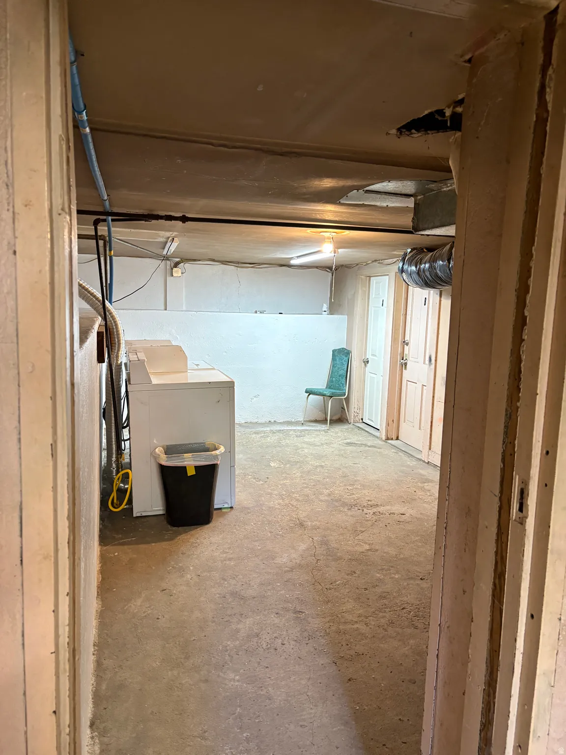 Concrete flooring in a versatile utility space with exposed ductwork and multiple access points