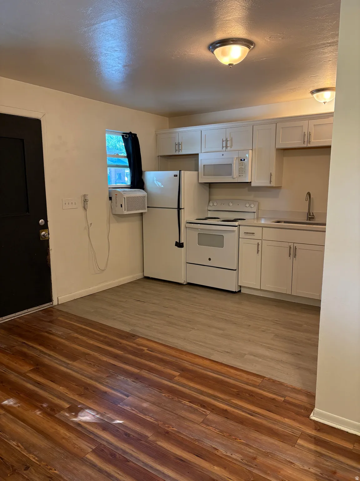 Kitchen area featuring white cabinetry, a white refrigerator, a white electric range, and a built-in white microwave