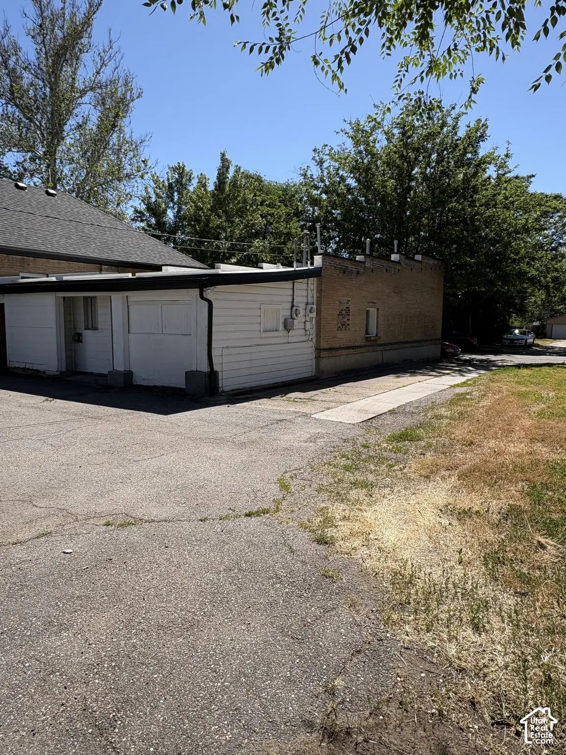Exterior building featuring white horizontal siding and brick construction