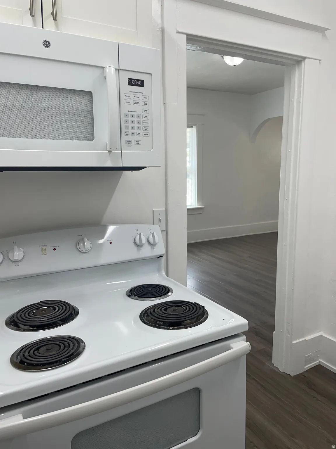 White electric range with coil burners and a matching over-the-range microwave