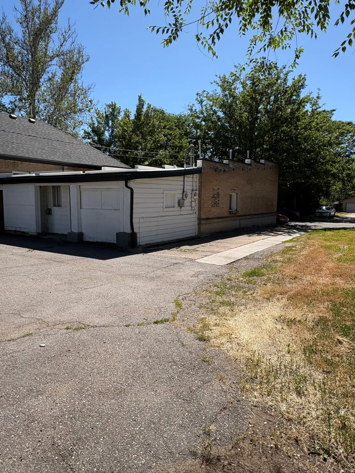 Exterior building featuring white horizontal siding and brick construction