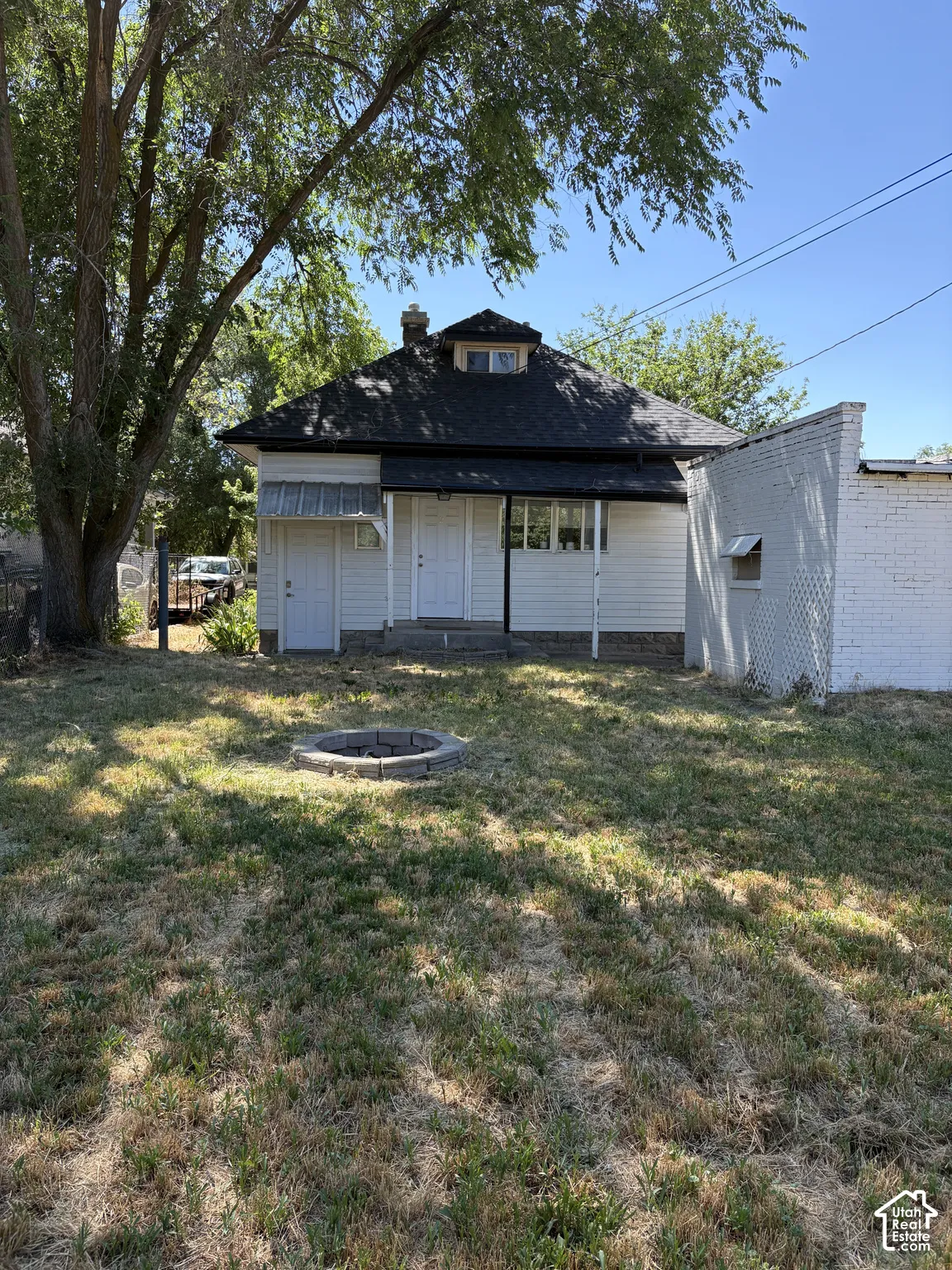 Rear exterior featuring white siding and a dormer window