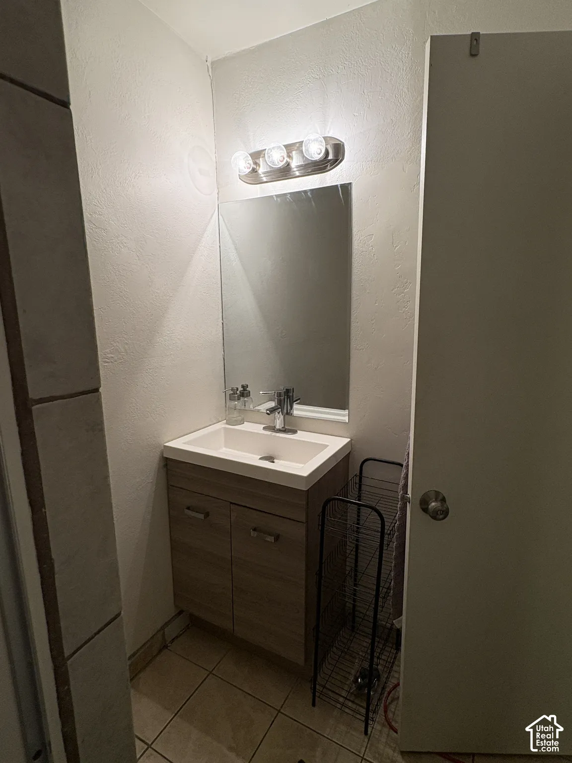 Bathroom vanity featuring a vessel sink, single-handle faucet, and wood-finish cabinetry with silver-tone pulls